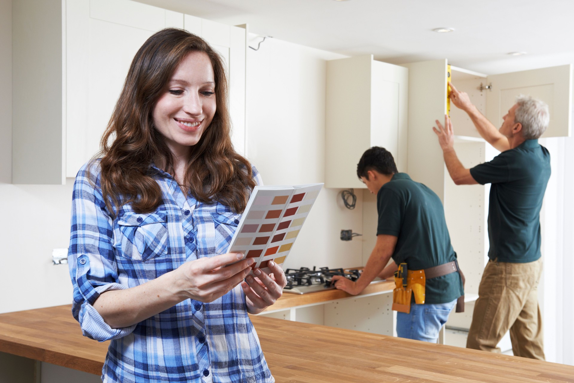 Woman Looking At Paint Chart In New Kitchen